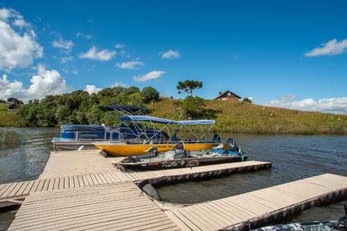 a yellow boat is docked at a dock at Divisa Experience Resort in São Francisco de Paula