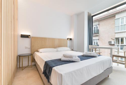 a bedroom with a bed and a large window at Stayaday Apartments Albufera in Madrid