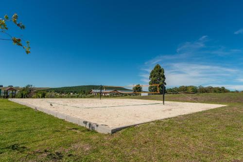 a volleyball court in a field with a net at Divisa Experience Resort in São Francisco de Paula