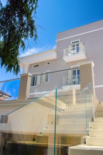 a white house with stairs in front of it at Doride Suites Boutique Hotel in Marina di Carrara