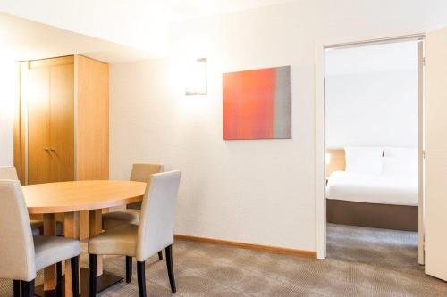 a room with a table and chairs and a bed at Novotel Gent Centrum in Ghent