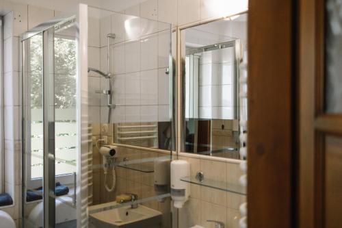 ein Bad mit einem Waschbecken und einem Spiegel in der Unterkunft Girls Willa in Krakau