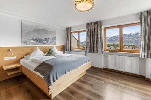 ein Schlafzimmer mit einem Bett und einem großen Fenster in der Unterkunft Berghaus Mucha - NATURPARK NAGELFLUHKETTE - Bergbahn im Sommer gratis in Bolsterlang