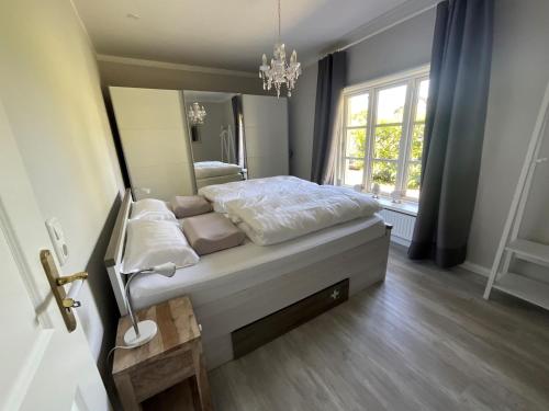 sypialnia z łóżkiem i dużym lustrem w obiekcie Kleine Villa Marleen, Ferienwohnung w mieście Schneverdingen