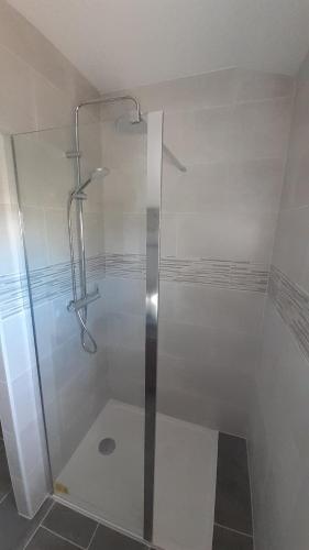 a shower with a glass door in a bathroom at Appartement zen in Saint-Nicolas-de-la-Grave