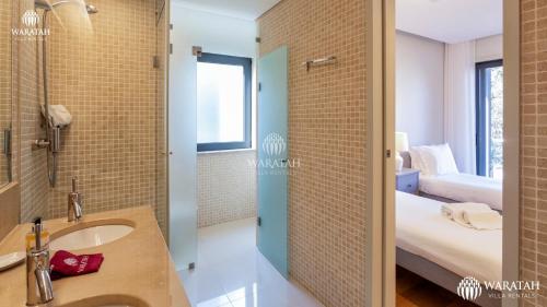 a bathroom with a sink and a shower and a bedroom at Apartment Micaela in Vale do Lobo