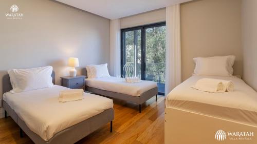 two beds in a room with a window at Apartment Micaela in Vale do Lobo