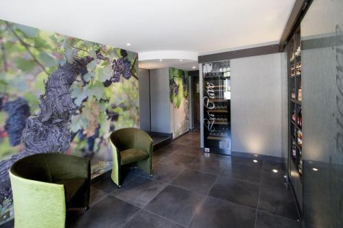 una sala de degustación con sillas verdes y una pintura en la pared en Vign 'Appart, en Nuits-Saint-Georges