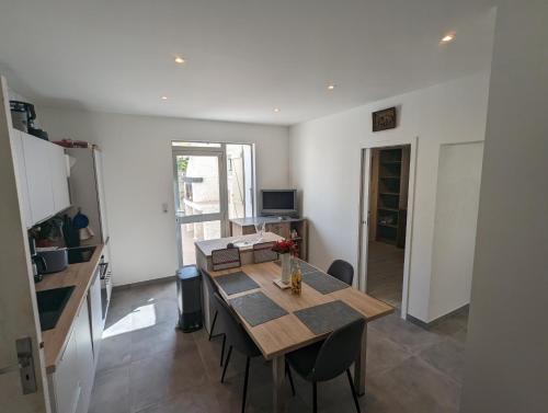 une salle à manger avec une table et des chaises en bois dans l'établissement Sol-y-Days ClauDid, Grand appartement rénové avec terrasse à 50m de la plage et très proche du centre ville, au Grau-du-Roi