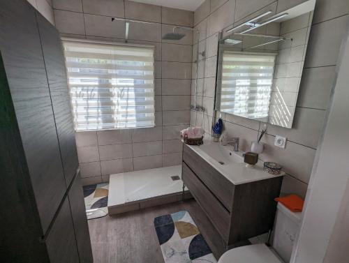 une salle de bain avec un lavabo et un miroir dans l'établissement Sol-y-Days ClauDid, Grand appartement rénové avec terrasse à 50m de la plage et très proche du centre ville, au Grau-du-Roi