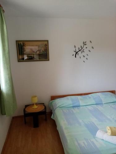 sypialnia z łóżkiem i stołem z obrazem na ścianie w obiekcie apartman Mirko w Puli