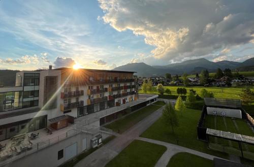 a view of a building with the sun setting behind it at Aldiana Club Salzkammergut und GrimmingTherme in Bad Mitterndorf