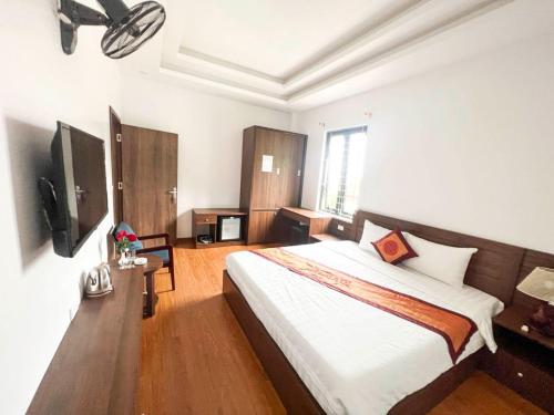 1 dormitorio con 1 cama grande y TV en Khách sạn Lâm Viên, en Pho Mới