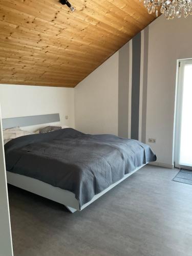 1 dormitorio con cama y techo de madera en Apartment Auszeit, en Bad Neustadt an der Saale