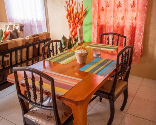een houten eettafel met 4 stoelen en een tafel bij Perfect Family Home Close to Roseau in Roseau
