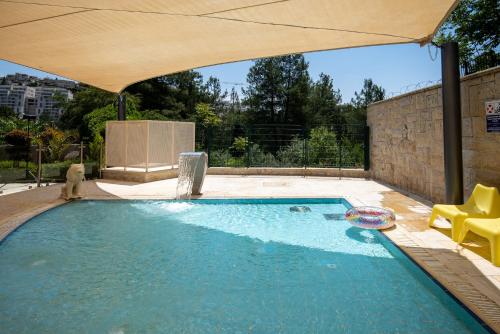 a swimming pool with an umbrella and a frisbee in it at Hotel Yehuda in Jerusalem