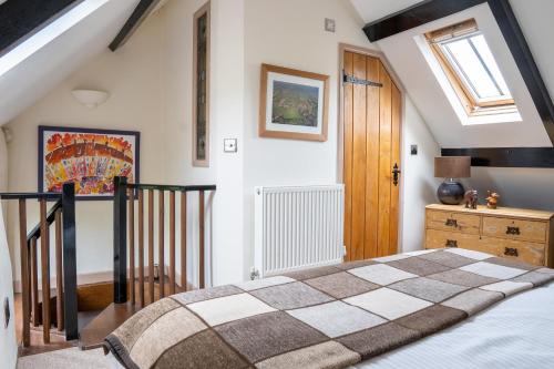 1 dormitorio con 1 cama y puerta de madera en Woodview - cosy 1840s cottage in Chew Valley and Mendip AONB, en Compton Martin