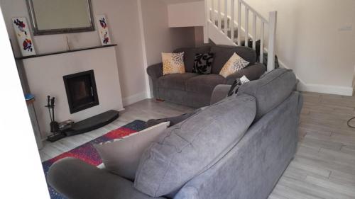 uma sala de estar com um sofá e uma lareira em The Helm Garden Terrace em Westport