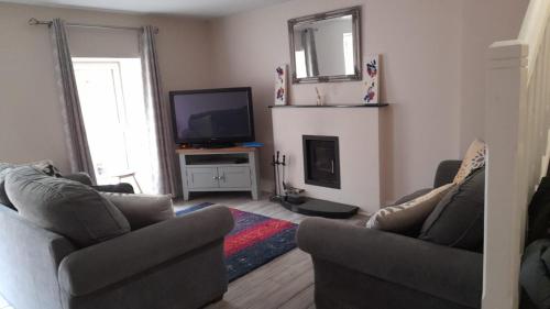 a living room with two couches and a television at The Helm Garden Terrace in Westport