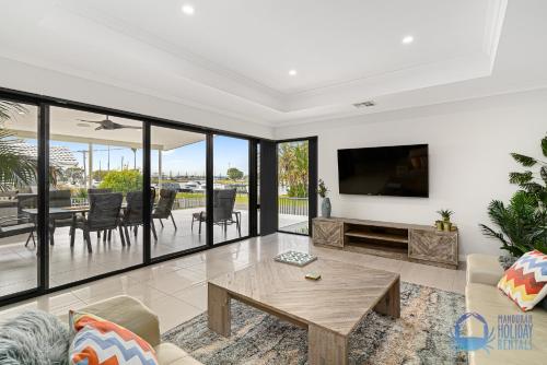 a living room with a tv and a table at Water Lovers Haven in Mandurah in Mandurah