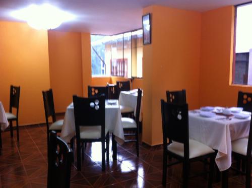 un comedor con mesas y sillas con mantel blanco en Hotel Rio Dorado MachuPicchu, en Machu Picchu