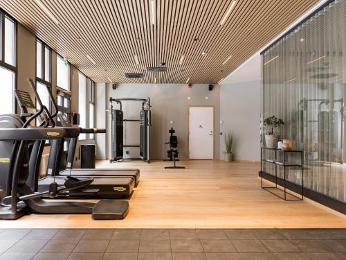 a gym with a treadmill and elliptical machines at Elite Hotel Adlon in Stockholm