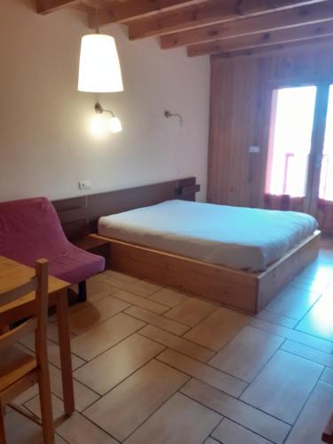 1 dormitorio con 1 cama, 1 silla y 1 mesa en Hotel restaurant la terrasse du mont bar hotel leydier en Allègre