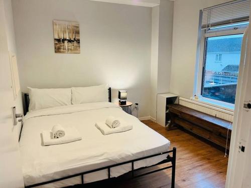 1 dormitorio con 1 cama con 2 toallas en Family Home in Residential Neighbourhood en Cardiff