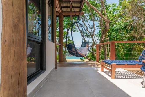 a porch with a swing and a hammock at Casa Ocean in Ubatuba