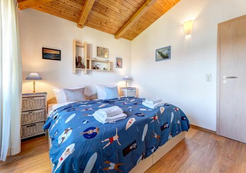 ein Schlafzimmer mit einer blauen Bettdecke mit Fisch darauf in der Unterkunft Ferienwohnung Sunset in Heringsdorf