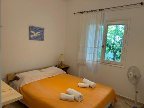 a bedroom with a bed with two towels on it at Orange Tree Garden in Pefkochori