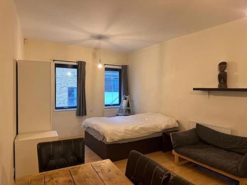 ロンドンにあるStudio Flat In Central Londonのベッドルーム1室(ベッド1台、ソファ、テーブル付)