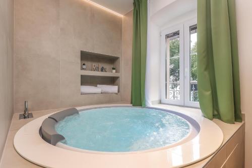 a large blue tub in a bathroom with a window at Ribica Luxury Rooms in Rijeka