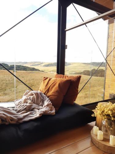 a bed in a room with a large window at Cabana Cambará in Cambará