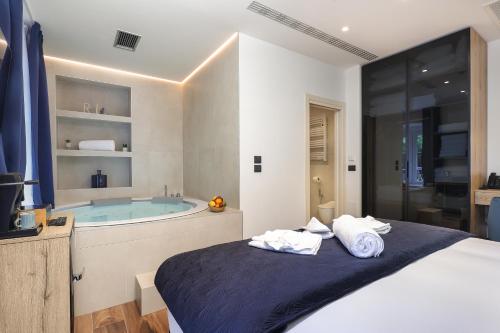 a bedroom with a tub and a bed with towels at Ribica Luxury Rooms in Rijeka