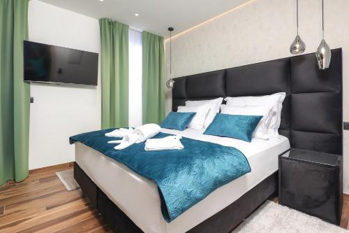 a bedroom with a large bed with a black headboard at Ribica Luxury Rooms in Rijeka