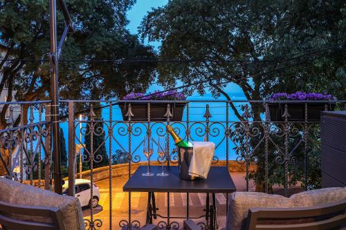 a table on a balcony with a view of the ocean at Ribica Luxury Rooms in Rijeka