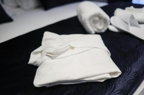 a pile of white towels sitting on a bed at Ribica Luxury Rooms in Rijeka