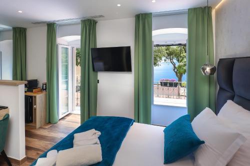 a bedroom with a bed with a view of the ocean at Ribica Luxury Rooms in Rijeka