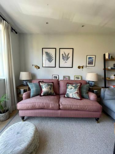 un soggiorno con divano rosa in una camera di Bright & Stylish 1BD Flat - Wandsworth Town a Londra