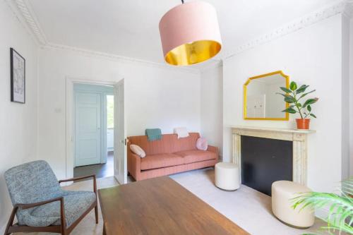 a living room with a pink couch and a fireplace at Charming & Central 2BD Flat - Islington in London