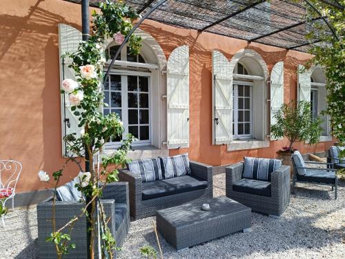 a patio with couches and chairs in front of a building at Les chambres d'hôtes du Domaine de Roque Haute in Portiragnes