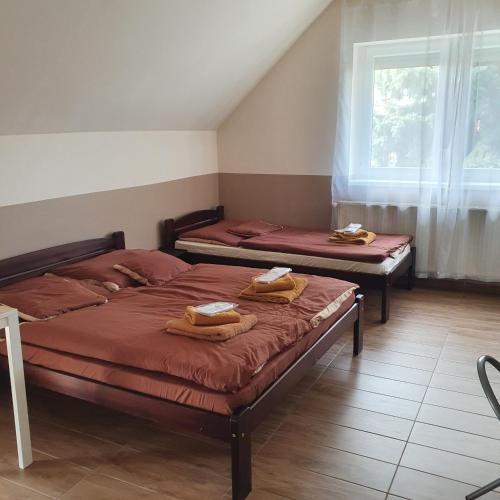 ein Schlafzimmer mit 2 Betten und Handtüchern darauf in der Unterkunft Airport MicrostorePanzió in Vecsés