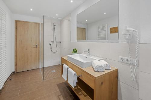 a white bathroom with a sink and a shower at Berghaus Mucha - Ferienwohnungen - Naturpark Partner in Bolsterlang