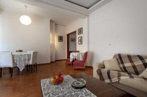 uma sala de estar com um sofá e uma mesa em Classy spacious central appartment em Volos
