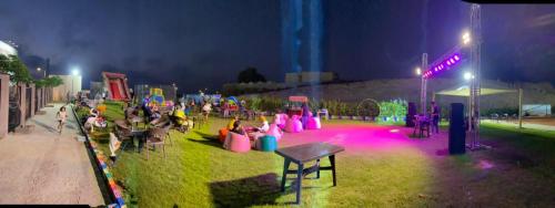 Un groupe de personnes dans un parc la nuit dans l'établissement الساحل الشمالي. قريه جراند هيلز الكيلو60, à Dawwār ‘Abd Allāh