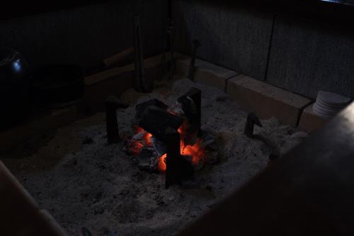 a fire pit in a dark room with snow at 古民家ゲストハウス結舎-YUINOYA- in Nakanoto