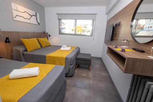 a small room with two beds and a mirror at HOTEL CONCEPT BARILOCHE in San Carlos de Bariloche