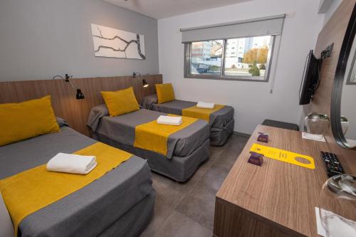a small room with two beds and a couch at HOTEL CONCEPT BARILOCHE in San Carlos de Bariloche