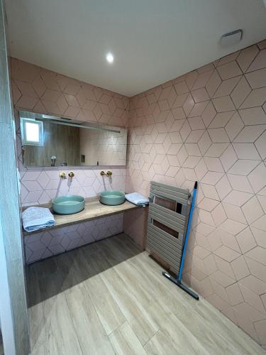 une salle de bain avec deux lavabos et un miroir dans l'établissement Au domaine des sources, à Grosbreuil